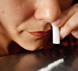 Primer plano de una mujer consumiendo una raya de cocaína