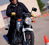 Motociclista sin guantes manejando una moto