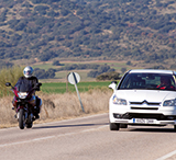 Turismo adelantando a una motocicleta en carretera