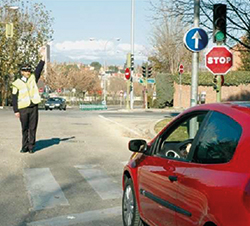 Intersección con semáforo, señal vertical y agente