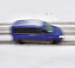 Automóvil circulando por una calzada con nieve