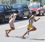 Dos niñas atraviesan a la carrera una carretera