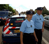 Imagen de un control policial de tráfico en Francia con dos agentes de la Gendarmería, una mujer y un hombre de pie, con dos coches policiales a sus espaldas.